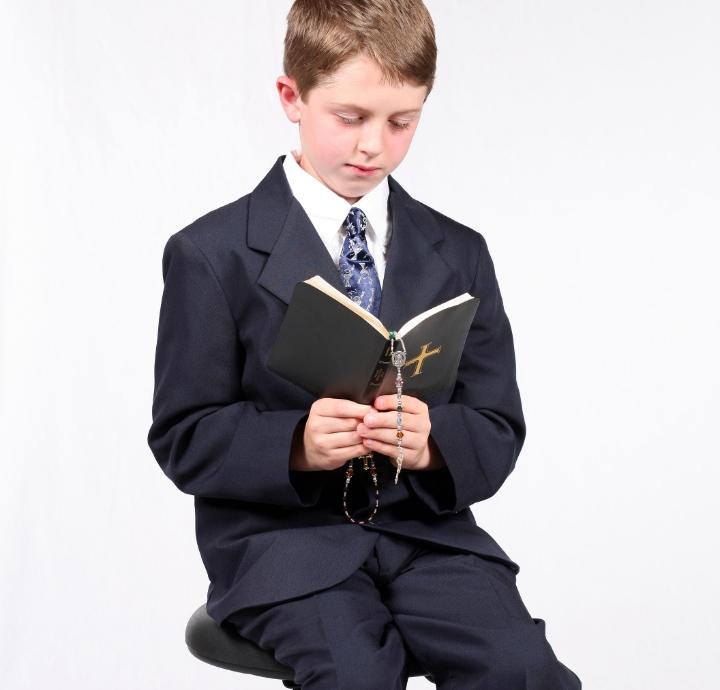 chłopiec w garniturze czyta ksiażkę